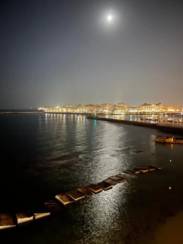 Nächtlicher Blick auf Meer und Hafen