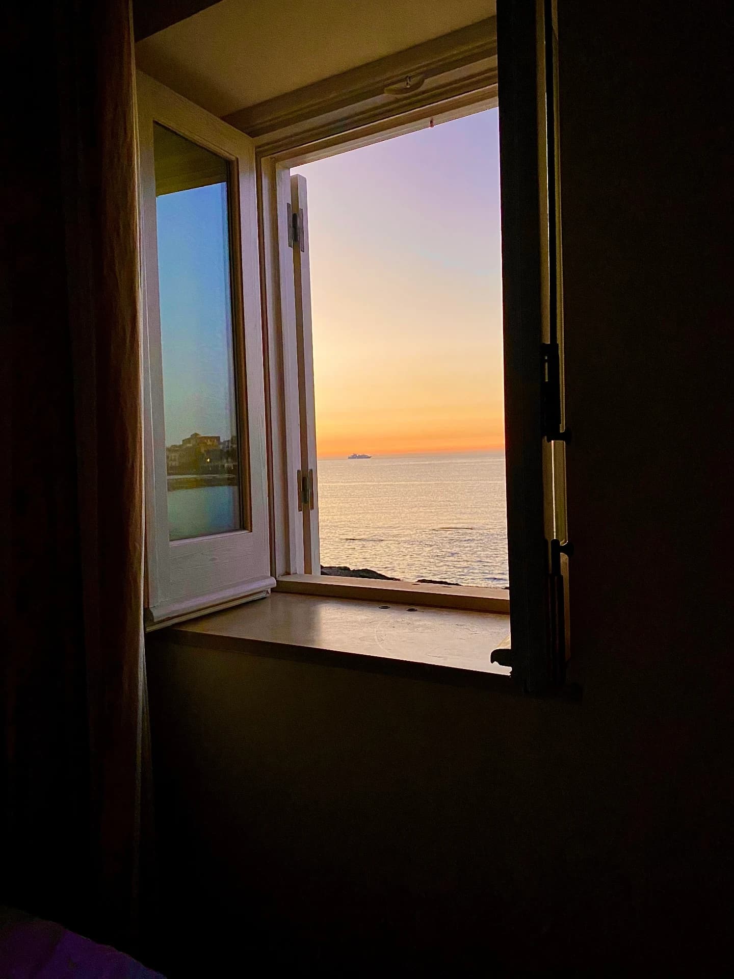 Fenster mit Blick aufs Meer bei Sonnenuntergang
