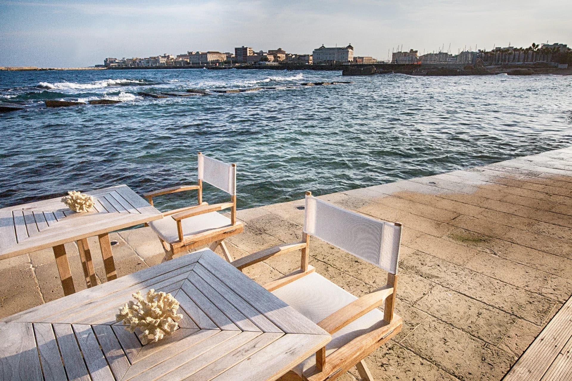 Holzliegen auf der Terrasse am Meer