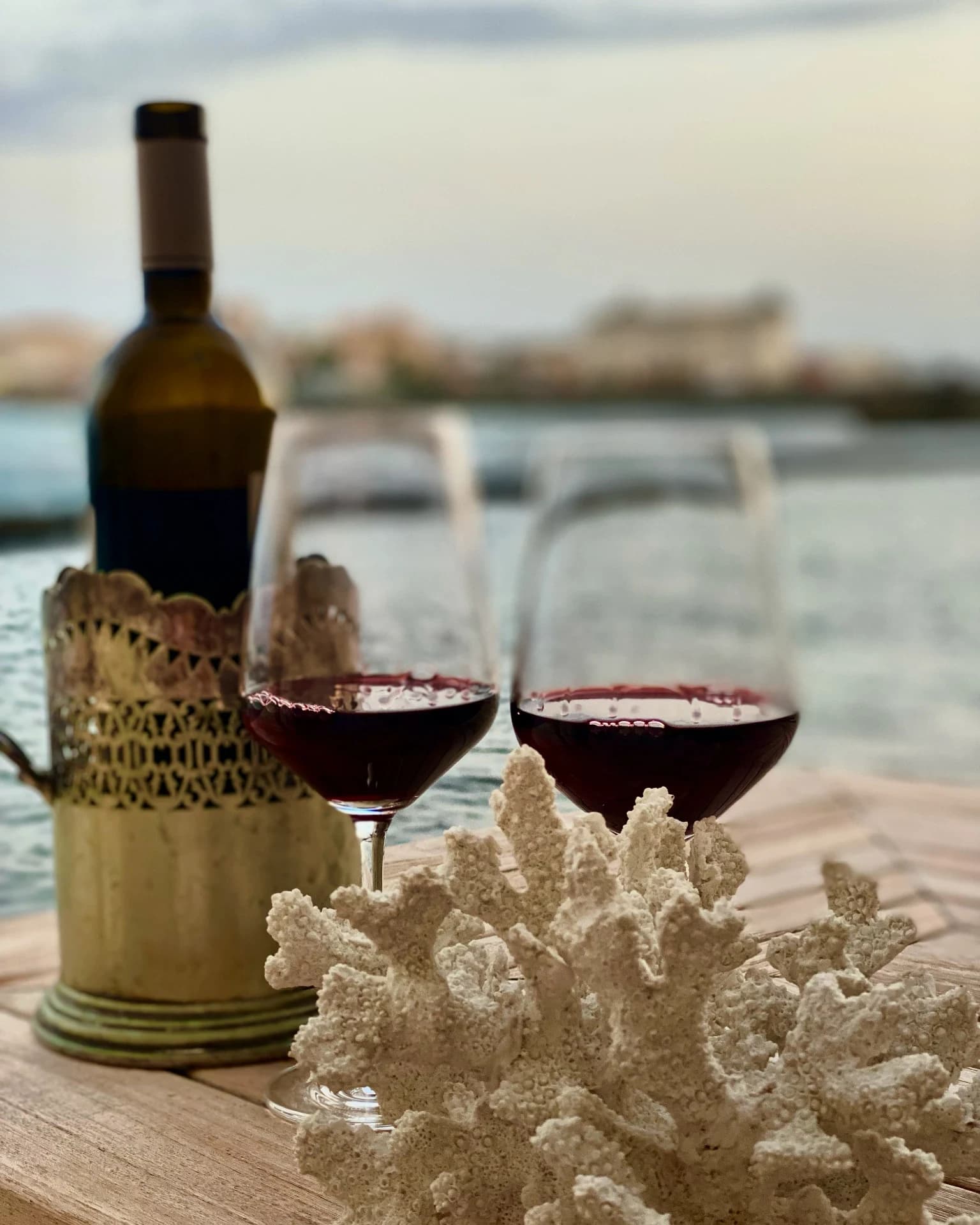 Wein und Koralle auf der Terrasse am Meer