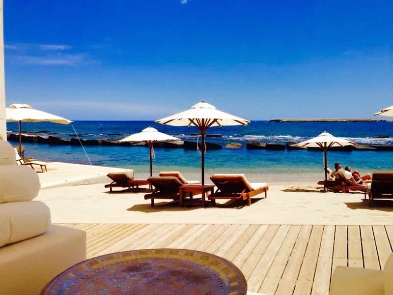 Beachclub mit Deck und Sonnenschirmen am Meer