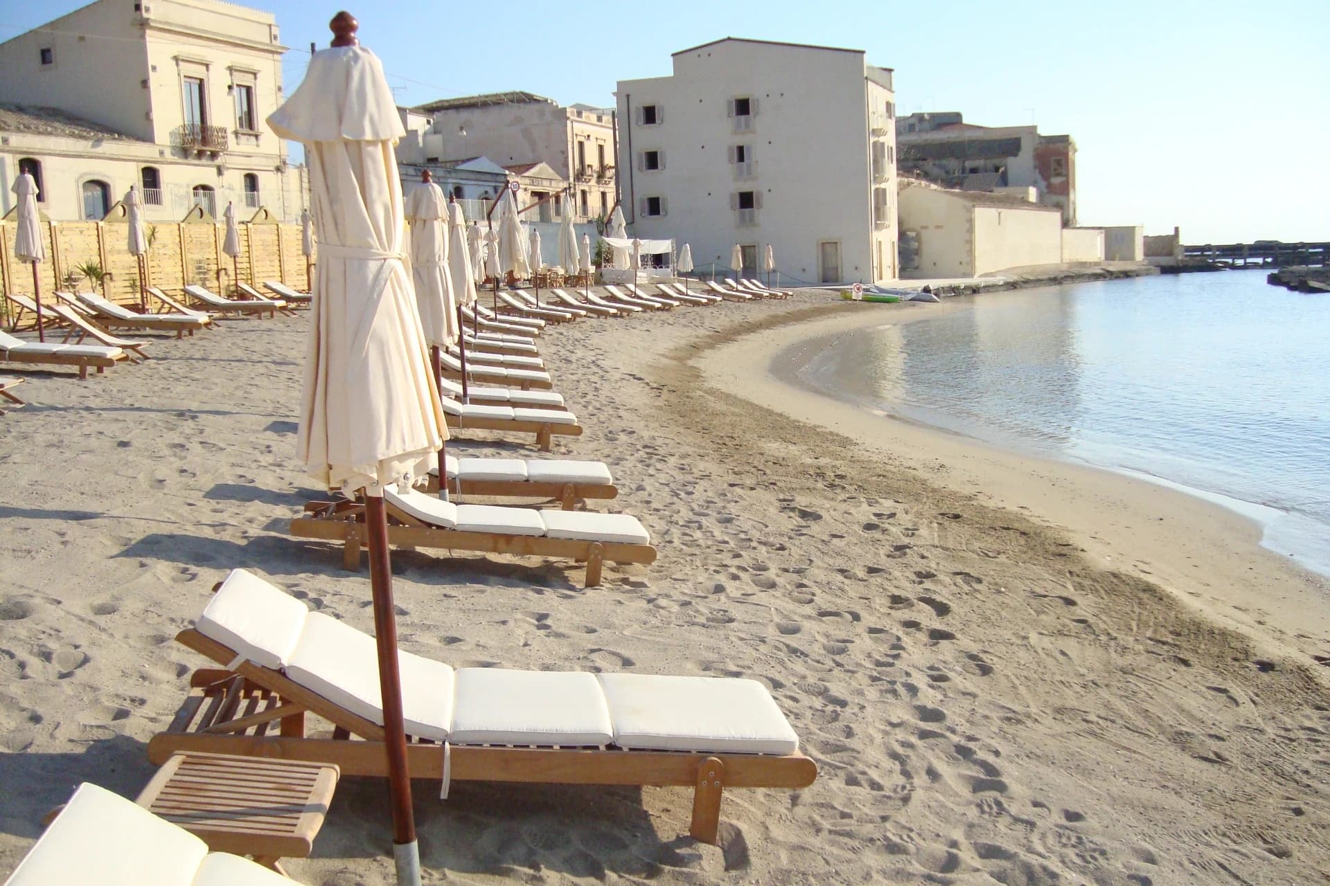 Strand mit weißen Sonnenschirmen und goldenem Sand