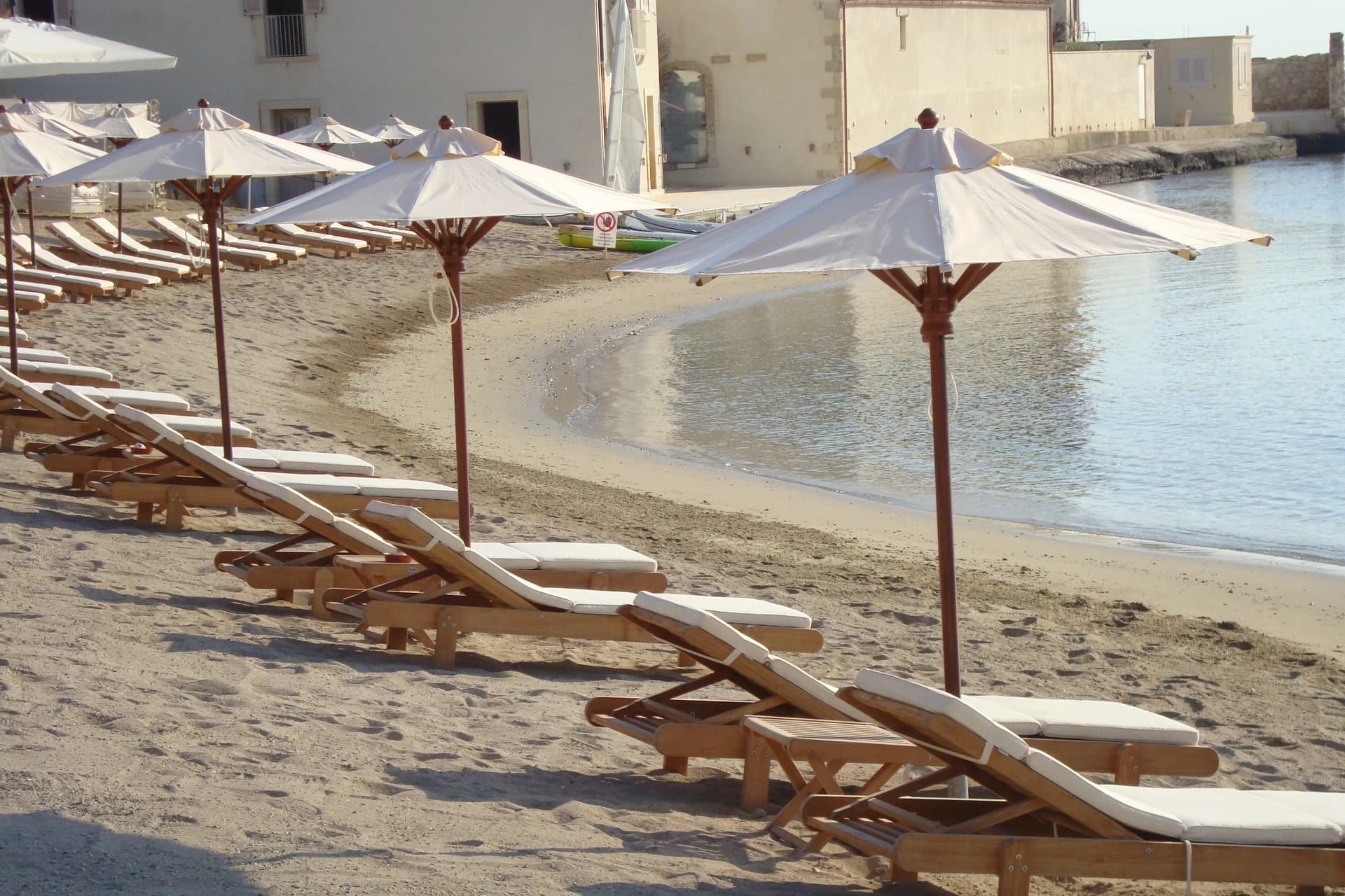 Bucht mit Sonnenschirmen und türkisfarbenem Meer im Musciara Resort